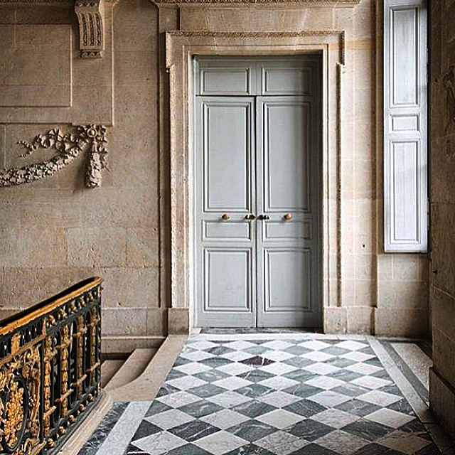 Formal French hallway with marble floor, limestone wall and bronze railing